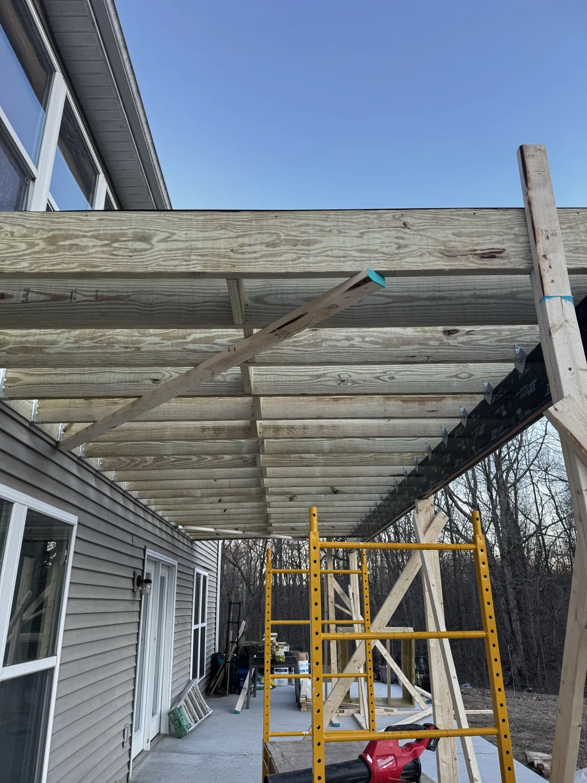 Covered deck framing with joists and posts under construction